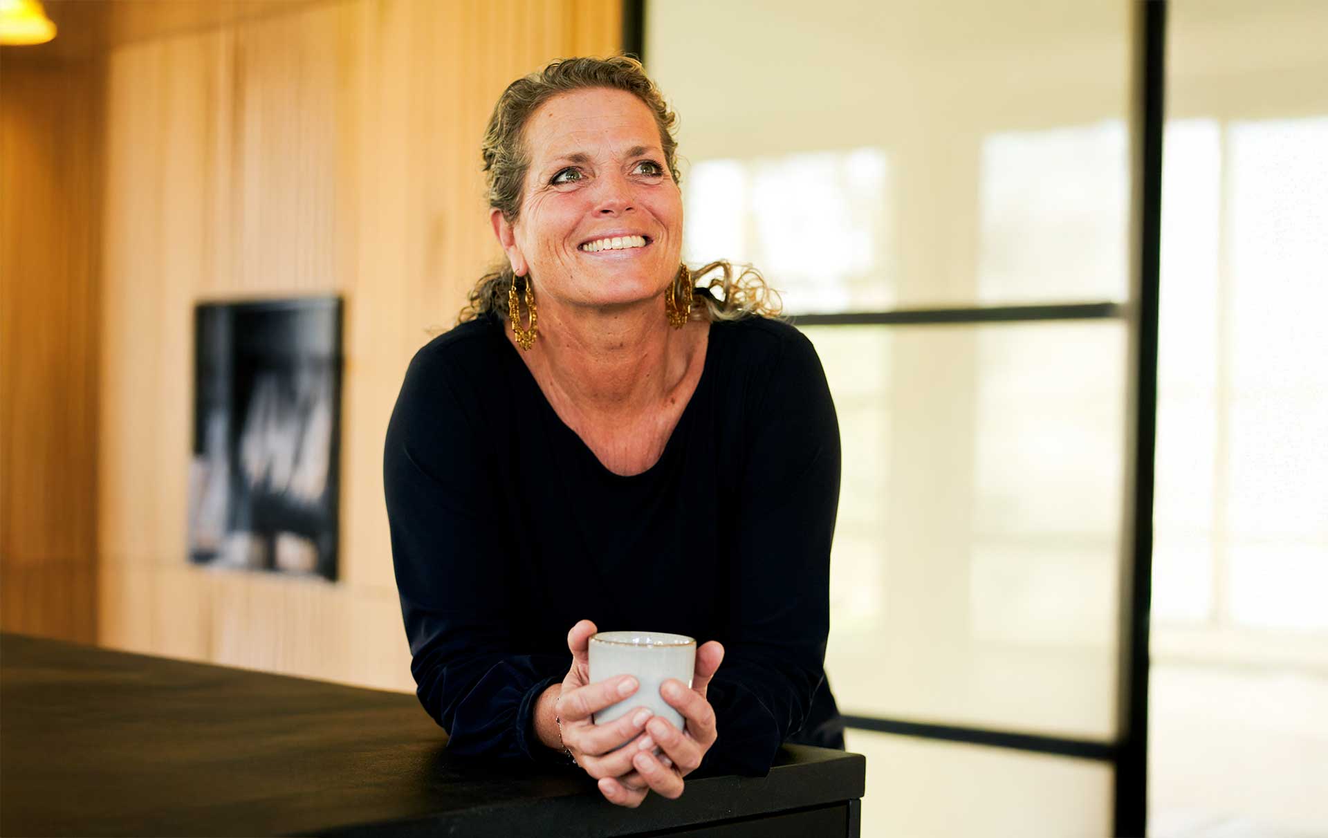Merel sitting at a table, looking into the camera
